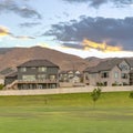 Homes overlooking immense mountain and cloudy sky