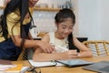 Homeschool Asian mother and little young girl student learning online class. E-learning Online Education concept.