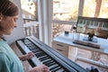 Homeschool European young boy learning piano from computer connecting to internet music online class by school teacher.