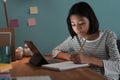 Homeschooling Asian girl doing homework And study online with tablet at a desk at night Royalty Free Stock Photo