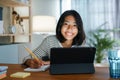 Homeschooling Asian girl doing homework And study online with tablet at the desk night. Portrait of Asia child happiness and