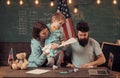 Homeschooling concept. American family at desk with son making paper planes. Kid with parents in classroom with usa flag Royalty Free Stock Photo