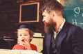 Homeschooling concept. Enthusiastic kid studying with teacher. Father checking homework, helps to boy, son. Teacher in Royalty Free Stock Photo