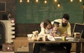 Homeschooling concept. Parents teaches son, chalkboard on background. Boy listening to mom and dad with attention Royalty Free Stock Photo