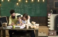 Homeschooling concept. Parents teaches son, chalkboard on background. Boy listening to mom and dad with attention Royalty Free Stock Photo