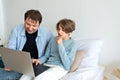 Homeschooling, home education, online learning concept. Father helping teenager son to do homework on laptop, parent and child boy