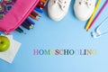 Homeschooling text over blue background with colorful pencils and sport shoes. Learn from home concept Royalty Free Stock Photo