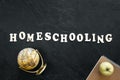 Homeschooling word made of wooden letters on a black background, top view.