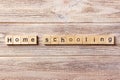 Homeschooling word written on wood block. Home schooling text on table, concept