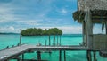 Homestay hut in beautiful blue lagoon and some island in background. Kordiris Homestay on Gam Island, West Papua, Raja