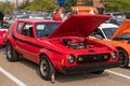 Homestead, Pennsylvania, USA July 21, 2021 A 1977 red with black stripes AMC Gremlin with a modified motor and it`s hood open Royalty Free Stock Photo