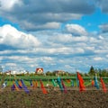 Kitchen gardens in the spring with beautiful clouds, fence with ribbons of colored fabrics - a