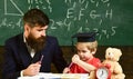 Hometask concept. Father checking hometask, helps to boy, son. Enthusiastic kid studying with teacher. Teacher in formal Royalty Free Stock Photo