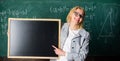 Hometask information. Teacher show school information. Teacher smart smiling woman hold blackboard blank advertisement