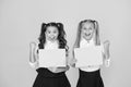 Homework done. Happy small children holding empty homework sheets on yellow background. Cute little girls smiling with