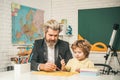 Homework help. Father helping his son to make homework. Elementary school. Pupil learning letters and numbers. Royalty Free Stock Photo