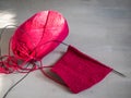 Homework, knitting with satin stitch of raspberry-colored hexagons and a skein of yarn