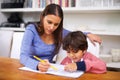 Homework is more fun when Mom helps me do it. a mother helping her son with his homework. Royalty Free Stock Photo