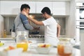 Homosexual Couple Eating Breakfast Cooking In Kitchen