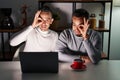 Homosexual couple using computer laptop doing ok gesture with hand smiling, eye looking through fingers with happy face Royalty Free Stock Photo