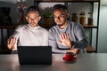 Homosexual couple using computer laptop doing stop sing with palm of the hand Royalty Free Stock Photo