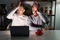 Homosexual couple using computer laptop surprised with hand on head for mistake, remember error