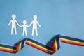 Homosexual family. Different kind of family. Paper cut family simbol with raindow ribbon