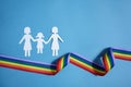 Homosexual family. Different kind of family. Paper cut family simbol with raindow ribbon