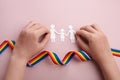 Homosexual family. Different kind of family. Paper cut family simbol with raindow ribbon