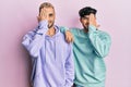 Homosexual gay couple standing together wearing casual clothes covering one eye with hand, confident smile on face and surprise Royalty Free Stock Photo