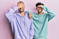 Homosexual gay couple standing together wearing casual clothes smiling and laughing with hand on face covering eyes for surprise Royalty Free Stock Photo