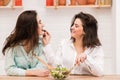 Happy gay couple feed each other at kitchen