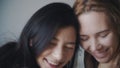 Two women hugging and smiling at each other in bedroom. Portrait of lesbian couple spend time together at home. LGBTQI