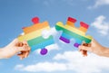 Hands matching puzzle pieces with gay flag colors