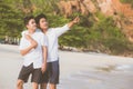 Homosexual portrait young asian couple standing pointing something together on beach in summer Royalty Free Stock Photo