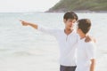 Homosexual portrait young asian couple standing pointing something together on beach in summer Royalty Free Stock Photo