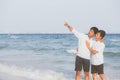 Homosexual portrait young asian couple standing pointing something together on beach in summer Royalty Free Stock Photo