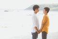 Homosexual portrait young asian couple standing together on beach in summer, asia gay holding hands going sea for leisure Royalty Free Stock Photo