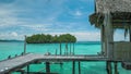 Homstay hut in beautiful blue lagoone and some island in background. Kordiris Homestay on Gam Island, West Papua, Raja