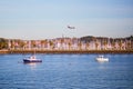 HONDARRIBIA, SPAIN - OCTOBER 27, 2021: Plane descending over the harbor with fishing boats in Hondarribia, Basque Country, Spain