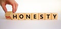 Honesty or dishonesty symbol. Businessman hand turns cubes and changes the word `dishonesty` to `honesty`. Beautiful white Royalty Free Stock Photo