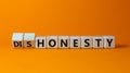 Honesty or dishonesty symbol. Turned cube and changed the word `dishonesty` to `honesty`. Beautiful orange background. Busines