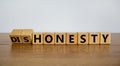 Honesty or dishonesty symbol. Turned cube and changed the word `dishonesty` to `honesty`. Beautiful wooden table, white backgr Royalty Free Stock Photo