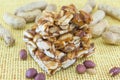 Honey bar with peanuts almonds and hazelnuts surrounded by roast Royalty Free Stock Photo