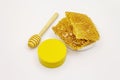 Honey, beeswax and wooden honey dipper isolated on white background