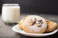 Honey biscuits with a walnut kernel on a white plate. Dark background. Biscuits with powdered sugar Royalty Free Stock Photo