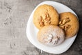 Honey biscuits with a walnut kernel on a white plate. Dark background. Royalty Free Stock Photo