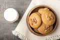 Honey biscuits with a walnut kernel in a wooden bowl on a light napkin. Biscuits with milk.