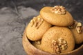 Honey biscuits with walnuts in a wooden bowl. Dark background