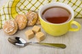 Honey-cake, lumpy sugar, teaspoon, napkin and cup of tea